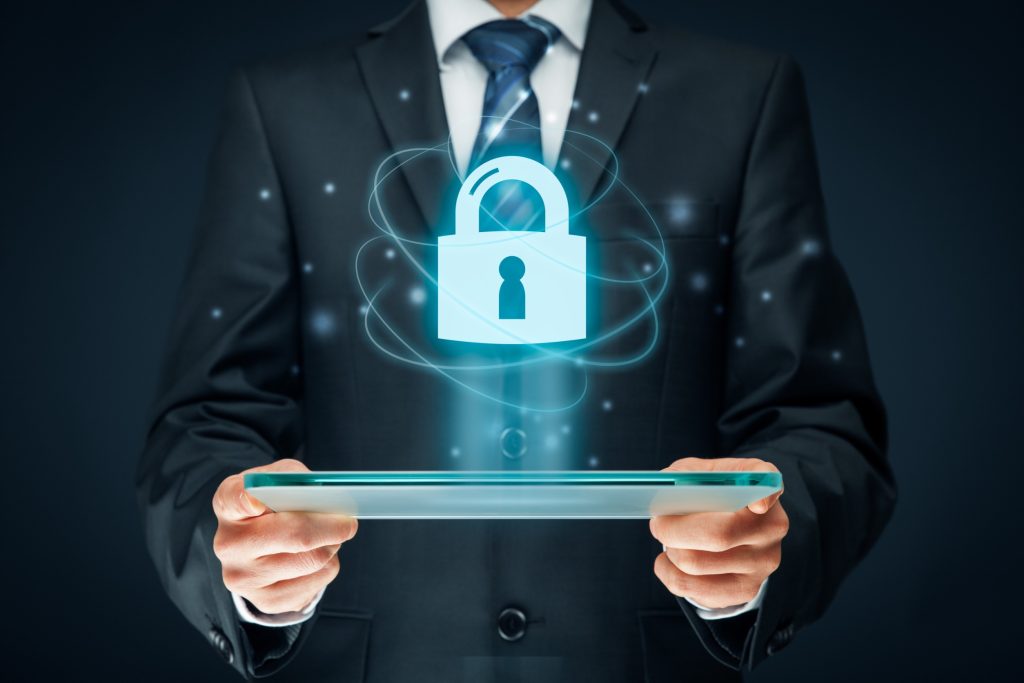Cyber security concept. Businessman holding tablet computer with padlock on blue background