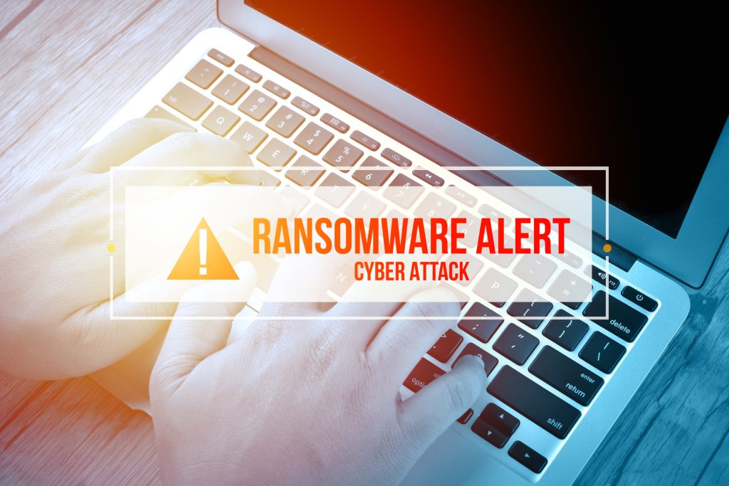 Hand Typing on keyboard with text RANSOMWARE ALERT